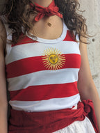 Débardeur rayé blanc et rouge avec un soleil jaune sur la poitrine. Top parfait pour tous les jours ou pour faire les fêtes de Bayonne et Pampelune. Mode femme boutique Ondres Sud Landes