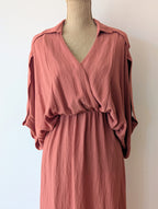 Robe longue terracotta en viscose avec fil dore.  Col chemise et drapé sur le devant. Manches chauves souris très élégantes.