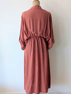 Robe longue terracotta en viscose avec fil dore.  Col chemise et drapé sur le devant.