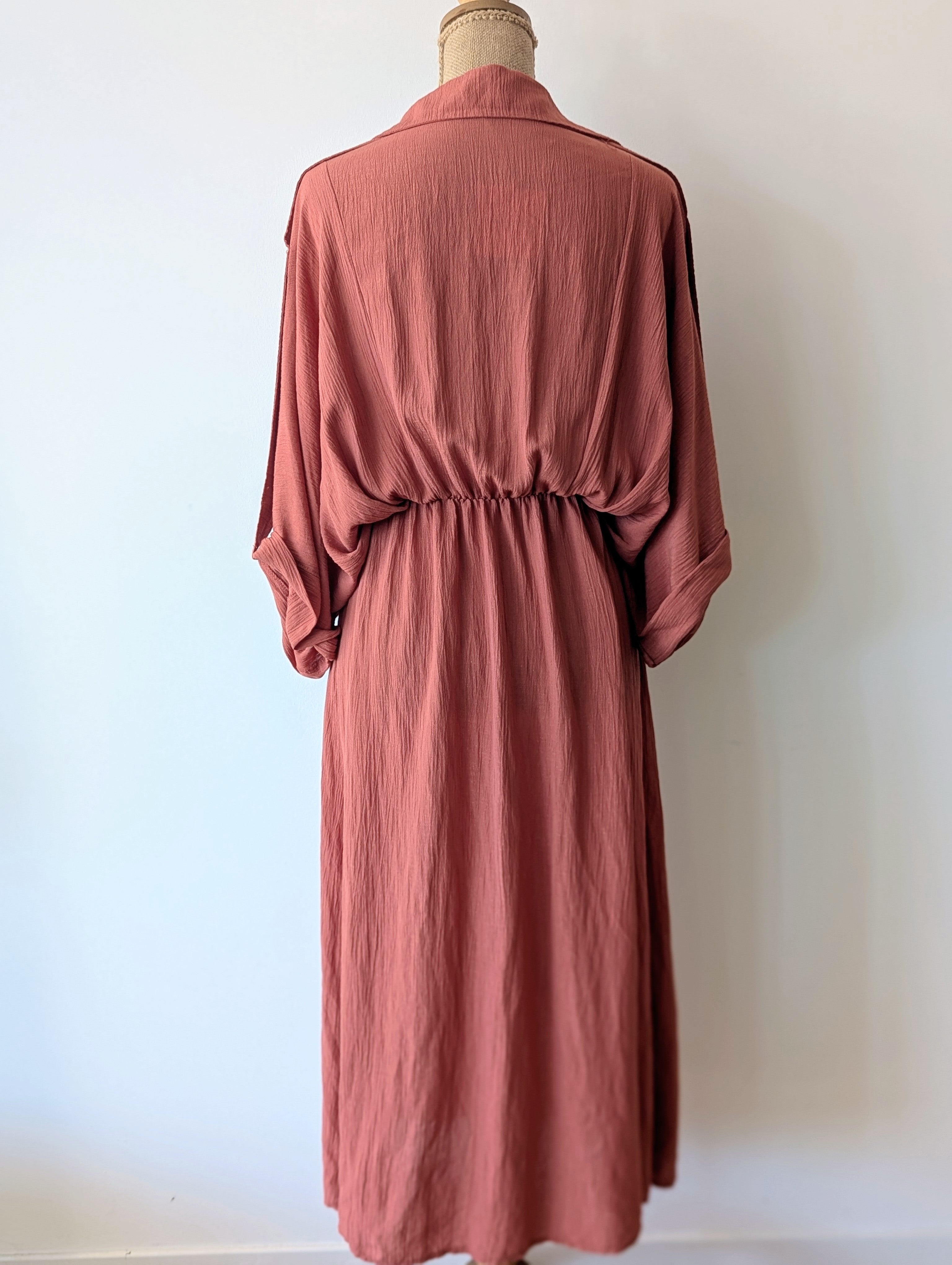 Robe longue terracotta en viscose avec fil dore.  Col chemise et drapé sur le devant.