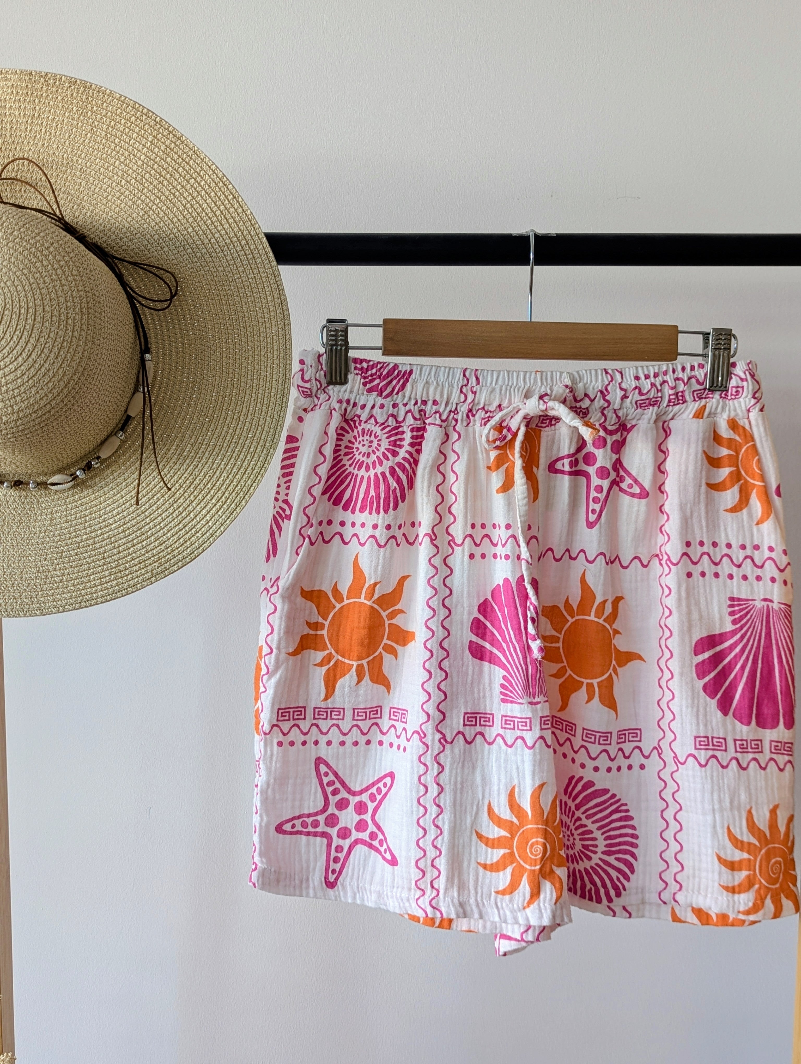 Short en Gaze de Coton blanc avec des soleil et des coquillages orange et fuchsia, très léger et respirant. Une taille élastique et deux poches, parfait pour ces chaleurs mode femme sud landes Ondres Hossegor Bayonne